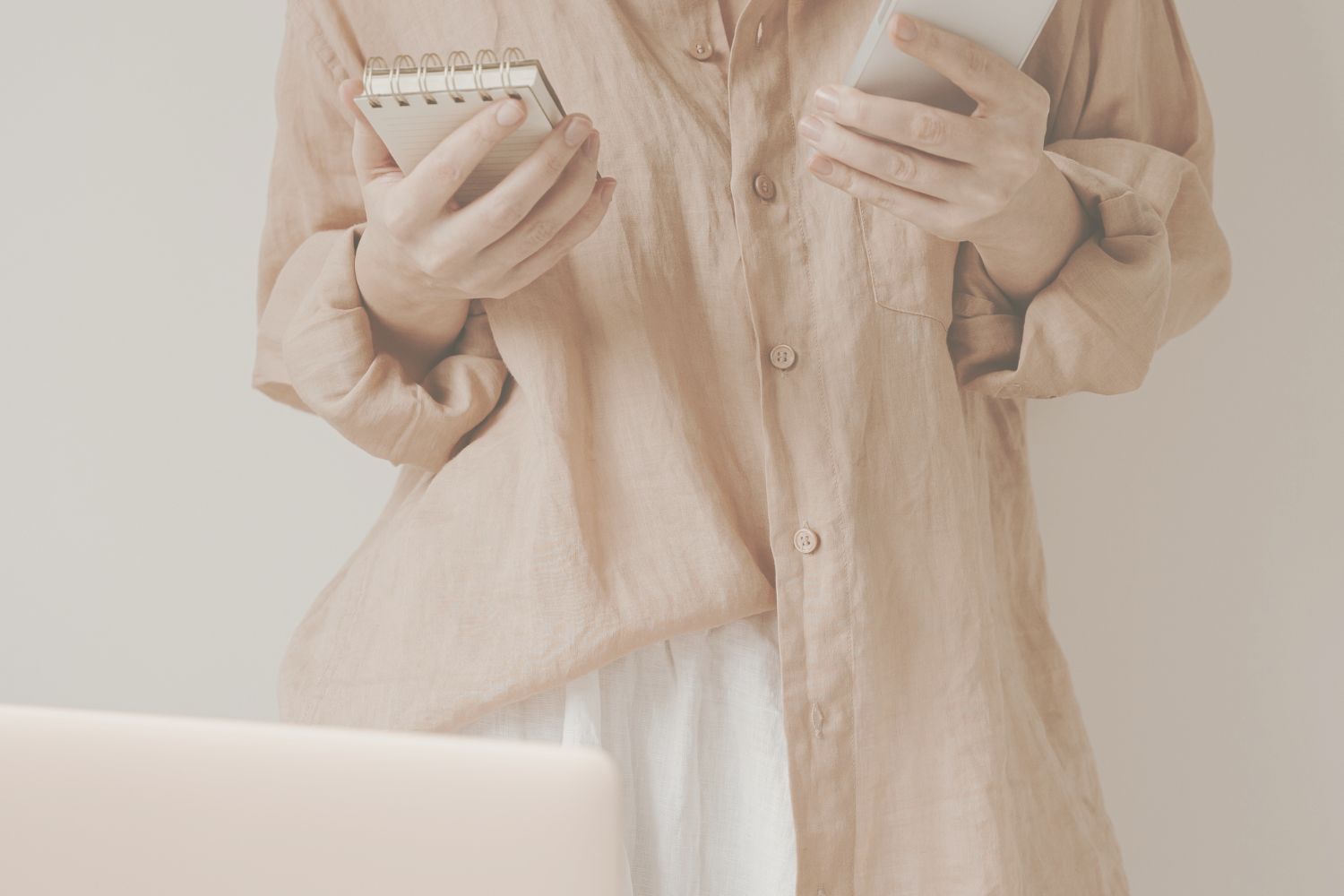 9 virtual assistant planning social media content on a phone in hand and holding a notebook